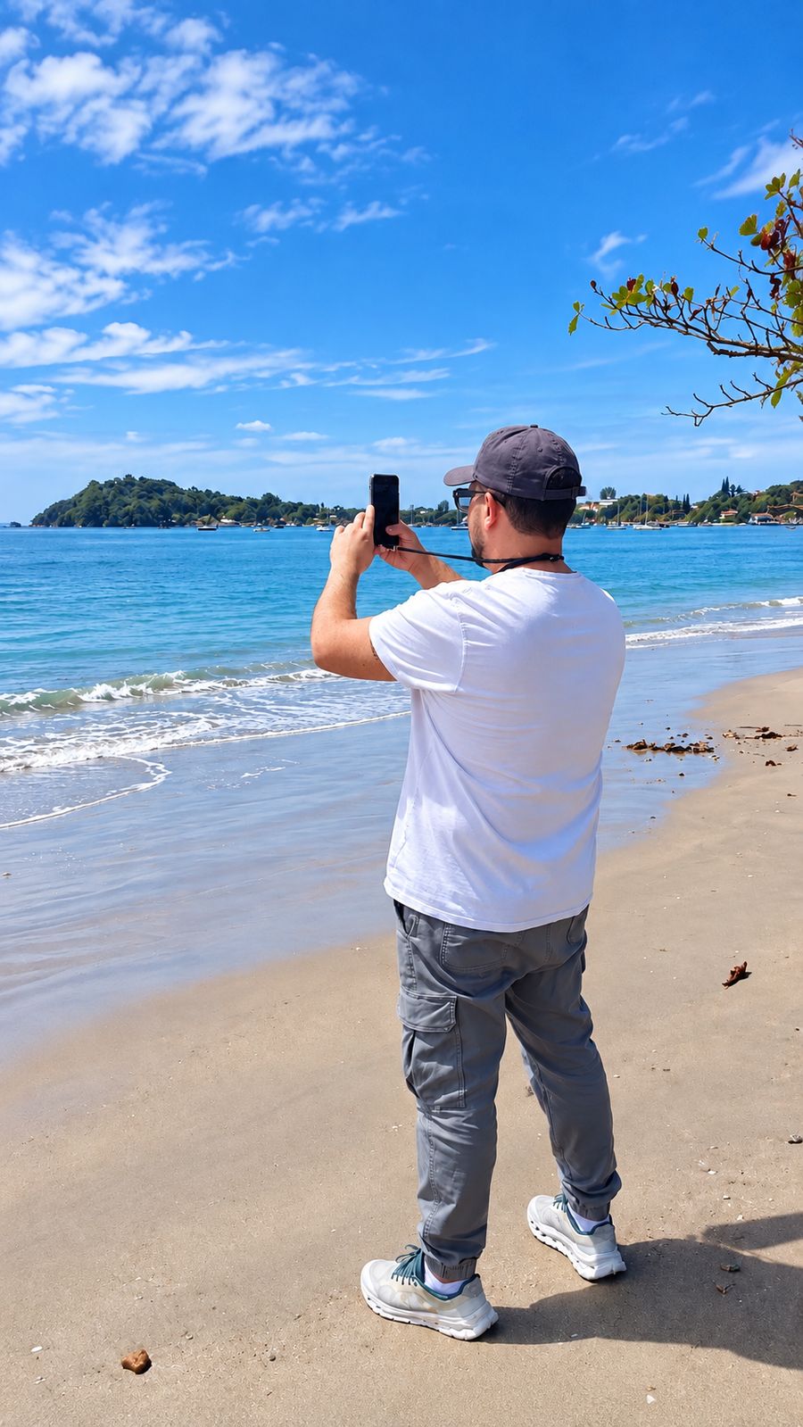 Enrique filmando o mar com o celular, na praia